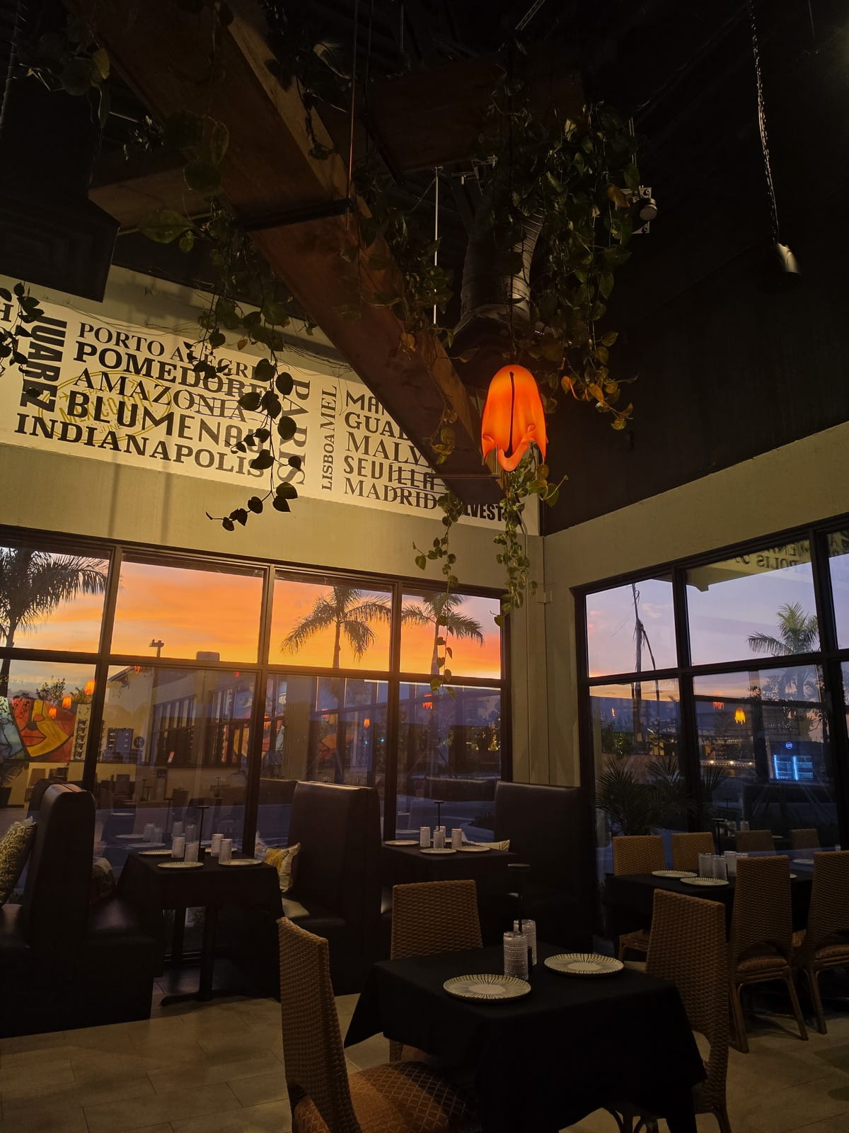 Port Tradition dining room — hanging gardens, Talavera tile booths, sunsetting